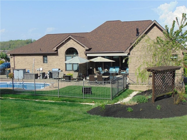 rear view of house with brick siding, a shingled roof, a lawn, and an outdoor hangout area