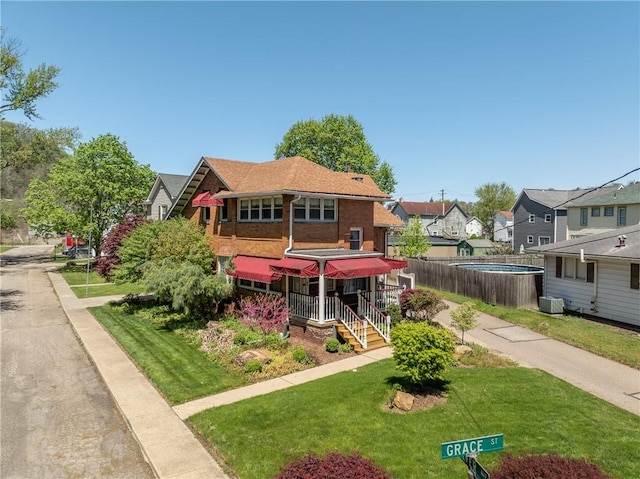 view of front facade with fence, a front yard, and a residential view