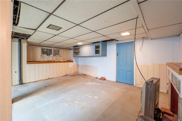 finished below grade area featuring a paneled ceiling