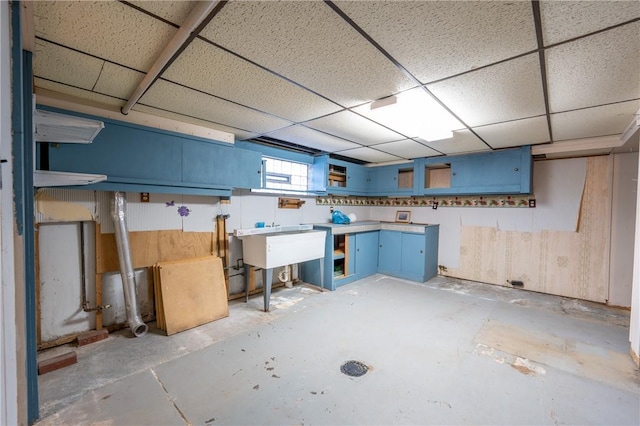 basement with a drop ceiling and a sink