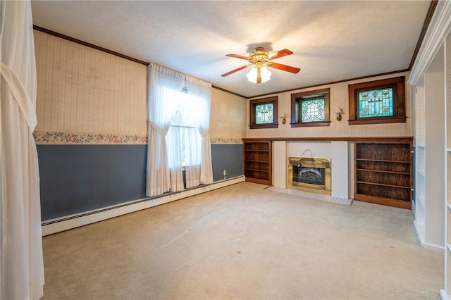 unfurnished living room featuring a ceiling fan, crown molding, a baseboard radiator, light carpet, and wallpapered walls