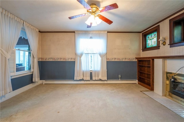 unfurnished living room with a ceiling fan, crown molding, a baseboard radiator, carpet, and wallpapered walls