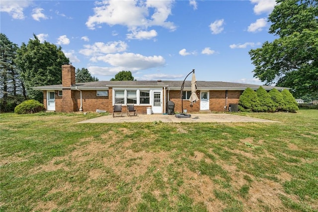 144 Harmony St, Connoquenessing Boro, PA 16027 - back of house featuring brick siding, a patio, a yard, and a chimney