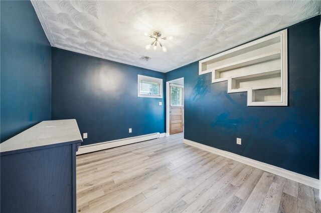 144 Harmony St, Connoquenessing Boro, PA 16027 - empty room featuring baseboards, a baseboard heating unit, wood finished floors, and visible vents