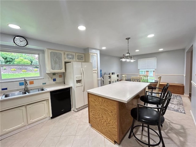116 Thornberry Dr, Churchill Boro, PA 15235 - kitchen with black dishwasher, white fridge with ice dispenser, a kitchen breakfast bar, light tile patterned floors, and a kitchen island