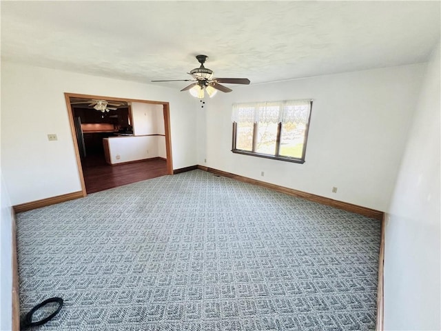 carpeted empty room with baseboards and ceiling fan