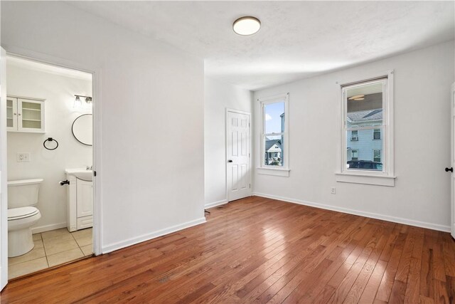 117 Vine St, Belle Vernon Wml, PA 15012 - unfurnished bedroom with wood-type flooring, baseboards, a sink, and ensuite bath