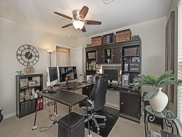 carpeted office with a textured ceiling, ceiling fan, and baseboards