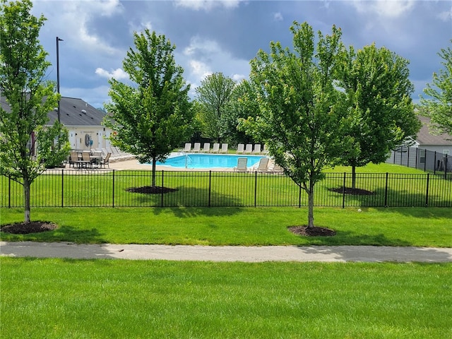 view of home's community with a yard, fence, and a pool