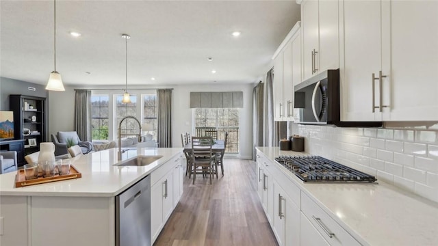 410 Barons Ct, Peters Twp, PA 15367 - kitchen featuring stainless steel appliances, a sink, wood finished floors, light countertops, and decorative backsplash
