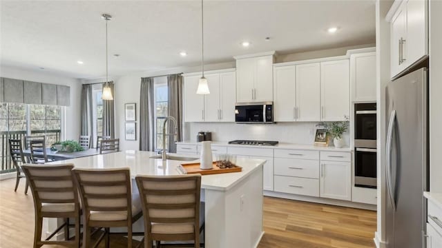 410 Barons Ct, Peters Twp, PA 15367 - kitchen featuring a sink, appliances with stainless steel finishes, recessed lighting, tasteful backsplash, and light wood-type flooring