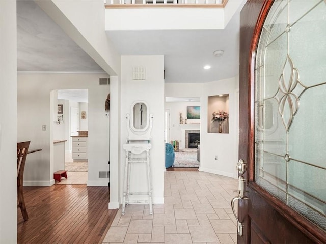 1312 Red Cut Lodge Rd, Derry Twp, PA 15650 - entrance foyer featuring baseboards, crown molding, visible vents, and a fireplace