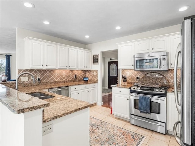 1312 Red Cut Lodge Rd, Derry Twp, PA 15650 - kitchen with light stone countertops, a sink, white cabinets, a peninsula, and stainless steel appliances