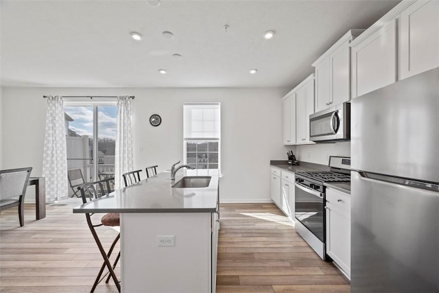 106 Sweetwater Dr, Moon/Crescent Twp, PA 15108 - kitchen featuring a kitchen island with sink, a kitchen bar, white cabinetry, a sink, and stainless steel appliances