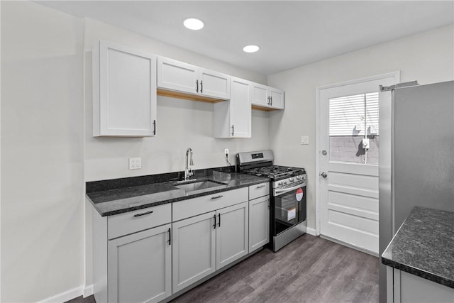113 Bryant Dr, Penn Hills, PA 15235 - kitchen featuring white cabinets, a sink, dark wood finished floors, dark stone countertops, and stainless steel appliances