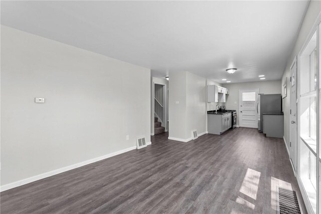 113 Bryant Dr, Penn Hills, PA 15235 - unfurnished living room with visible vents, stairs, dark wood-style flooring, and baseboards