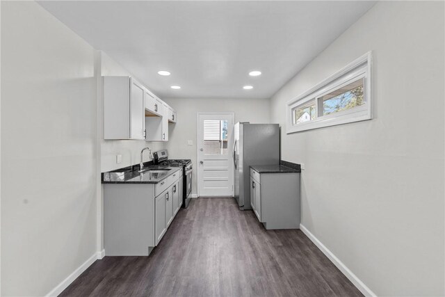 113 Bryant Dr, Penn Hills, PA 15235 - kitchen featuring dark countertops, baseboards, dark wood-style floors, a sink, and stainless steel appliances