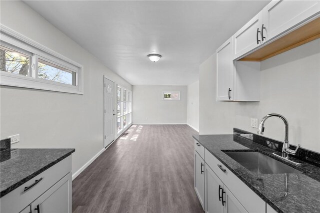 113 Bryant Dr, Penn Hills, PA 15235 - kitchen featuring dark wood-style flooring, baseboards, a sink, and dark stone countertops