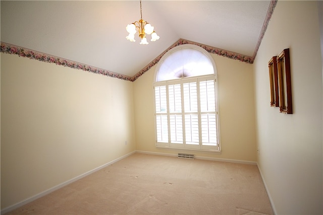 spare room with visible vents, baseboards, light colored carpet, a notable chandelier, and vaulted ceiling