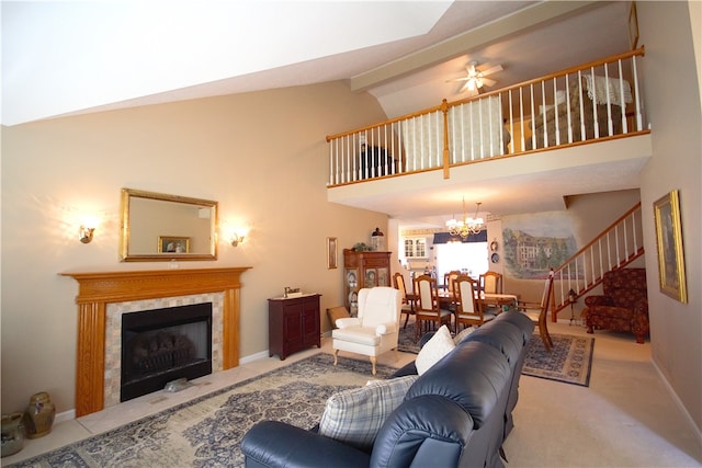 carpeted living room featuring high vaulted ceiling, ceiling fan with notable chandelier, baseboards, a high end fireplace, and stairway