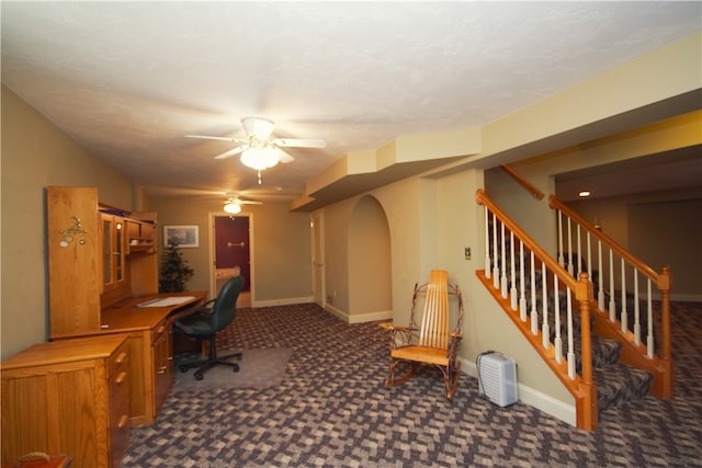 office area featuring carpet floors, a ceiling fan, baseboards, and built in desk