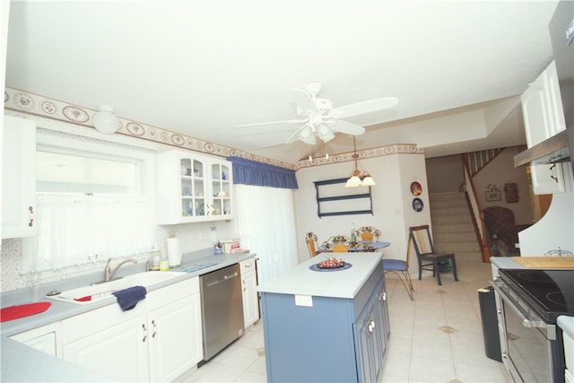 kitchen featuring white cabinets, ceiling fan, appliances with stainless steel finishes, light countertops, and blue cabinets
