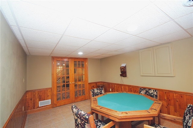 game room featuring wooden walls, visible vents, and a wainscoted wall