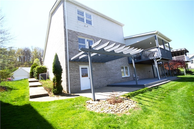 rear view of property with brick siding, a lawn, a pergola, and a patio