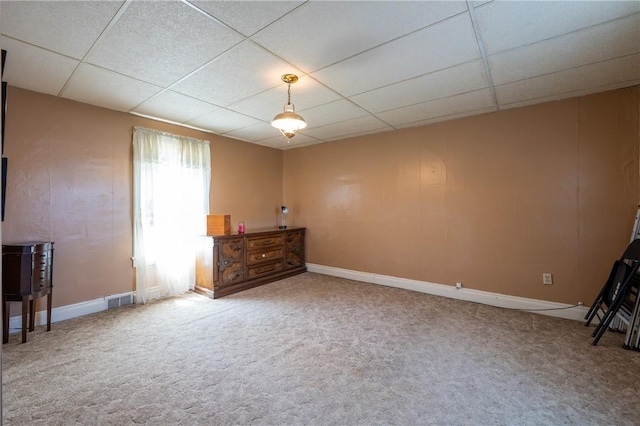 unfurnished room featuring baseboards, carpet flooring, a paneled ceiling, and visible vents