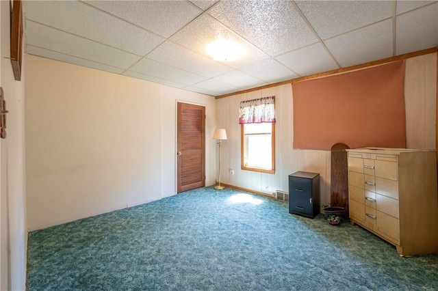 spare room featuring carpet floors, visible vents, and a paneled ceiling