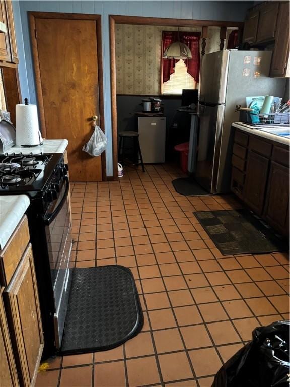 115 Woodrow Ct, Sharon, PA 16146 - kitchen featuring black gas range oven, freestanding refrigerator, and light tile patterned flooring