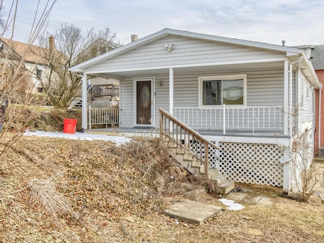 shotgun-style home featuring covered porch and stairway