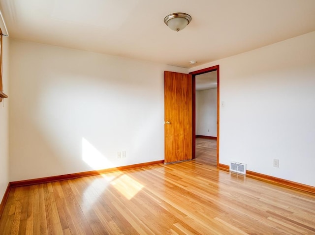 unfurnished room featuring light wood-style floors, baseboards, and visible vents