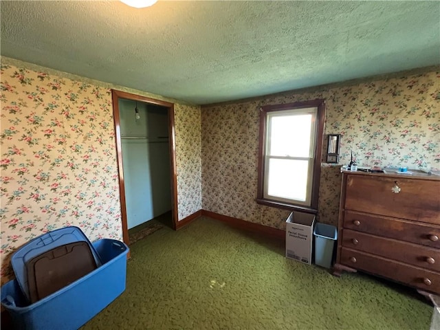 unfurnished bedroom with a closet, a textured ceiling, light carpet, and wallpapered walls