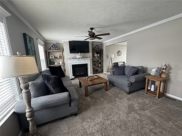 carpeted living room with ornamental molding, a textured ceiling, ceiling fan, and a fireplace