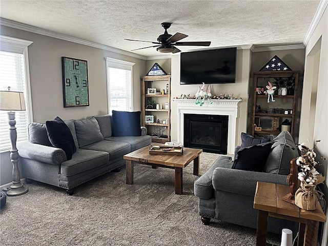 carpeted living area featuring a glass covered fireplace, ceiling fan, ornamental molding, and a textured ceiling