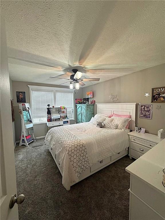 bedroom featuring a ceiling fan, a textured ceiling, and dark carpet