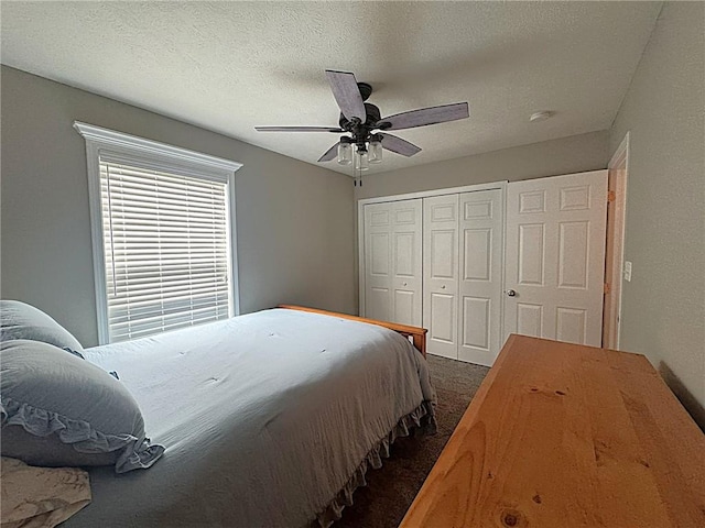 bedroom with dark colored carpet, a ceiling fan, and a closet