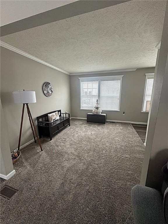 interior space featuring a textured ceiling, visible vents, crown molding, baseboards, and carpet flooring