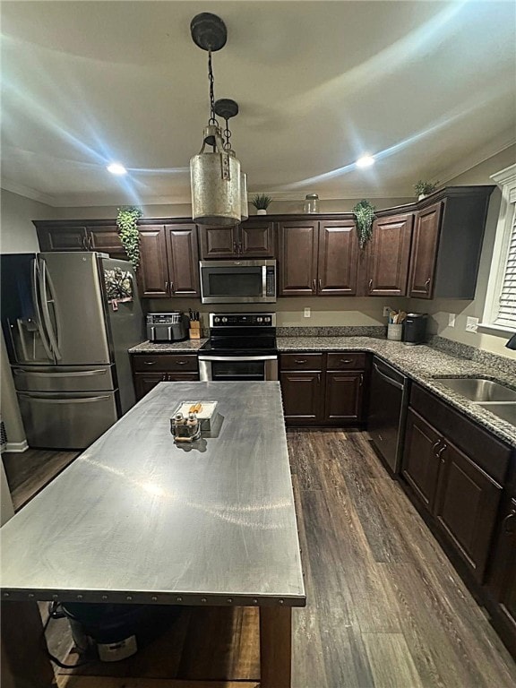 kitchen with dark brown cabinetry, dark wood-style flooring, a sink, ornamental molding, and stainless steel appliances