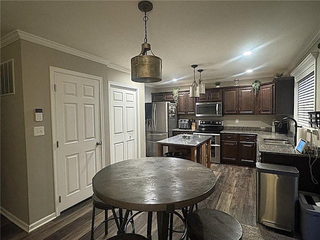 kitchen featuring dark brown cabinets, dark wood-style floors, a center island, a sink, and stainless steel appliances