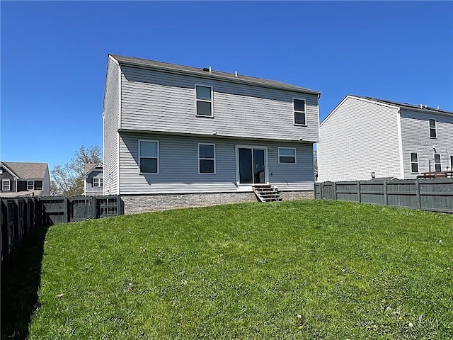 back of property featuring a yard, a fenced backyard, and entry steps