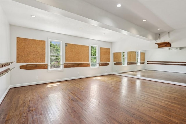 workout area featuring baseboards, recessed lighting, and wood finished floors