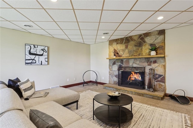 living room featuring visible vents, a fireplace, carpet flooring, and a paneled ceiling