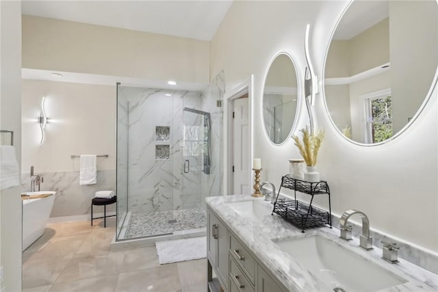 full bathroom featuring double vanity, a freestanding bath, a marble finish shower, and a sink