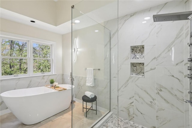 full bath featuring a soaking tub, recessed lighting, a marble finish shower, and tile walls
