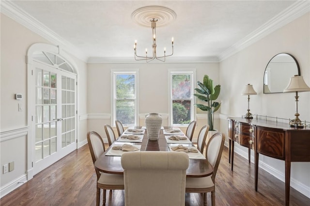 dining room with baseboards, a chandelier, ornamental molding, and wood finished floors