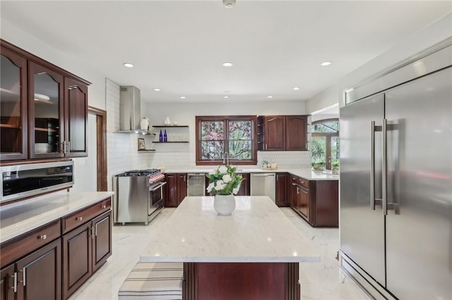 kitchen with open shelves, wall chimney exhaust hood, tasteful backsplash, and high quality appliances
