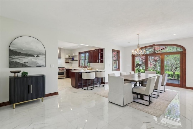dining space featuring baseboards, marble finish floor, and a notable chandelier