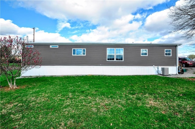 rear view of house featuring a yard and central air condition unit